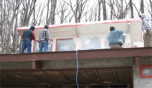 The second finish coat is sprayed on with a hopper gun